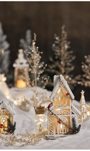 Close-up of glowing wooden Christmas house ornament in a cozy snowy winter scene