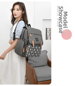 Detail of grey diaper backpack featuring white arrow patterns and leather zipper accents