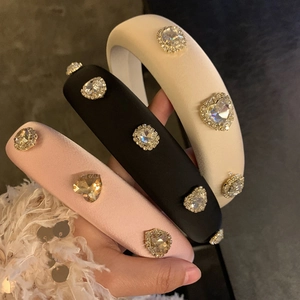 Detailed view of pink, black, and beige satin headbands with sparkling heart rhinestones