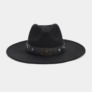 Close-up of vintage metal bull head buckle and turquoise beads on black wide brim fedora