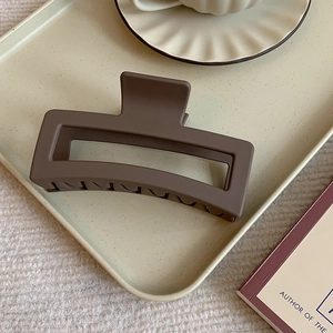 Matte dark brown square shark hair claw clip 10.5cm for thick hair on beige tray