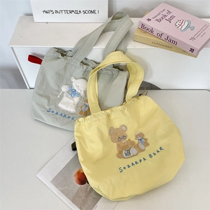 Detailed view of canvas drawstring tote bags with cute 3D animal embroidery and texture