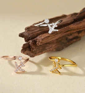 Micro-inlaid zircon plane rings in gold, silver and rose gold on a natural wood base