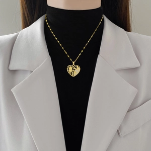 Elegant hollow heart pendant necklace in gold with diamonds worn by a model