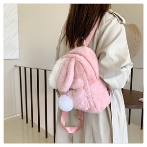 Lifestyle view of a pink plush rabbit backpack with long ears and white pom tail