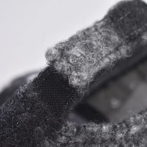Macro view of textured grey plaid fabric and reinforced black strap on the baseball cap