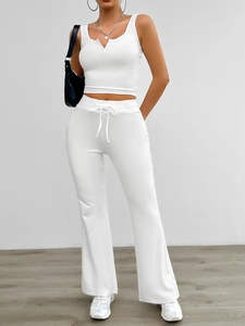 Detail of white yoga set featuring a cropped V-neck tank top and wide-leg flare pants