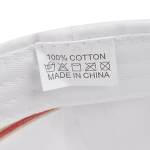 Detail showing the 100% cotton care label and stitching on a white baseball cap