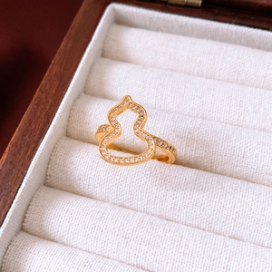 Makroaufnahme eines vergoldeten hohlen Kürbis-Rings mit weißen Zirkon-Inlays
