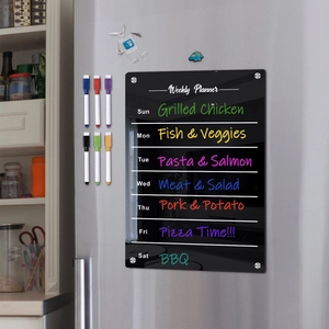 Macro detail of acrylic weekly planner with magnetic markers on a refrigerator