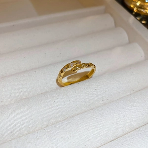 Macro detail of gold-plated butterfly ring showing irregular texture and pavé set zircons