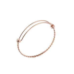 Macro detail of rose gold twisted wire bracelet featuring an adjustable sliding clasp