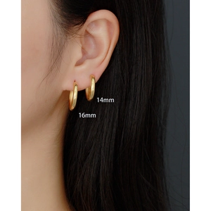 Detail showing 14mm and 16mm gold geometric hoop earrings worn on female ear model