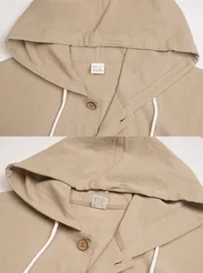 Detail of linen hooded shirt showing natural fabric texture, buttons and care label
