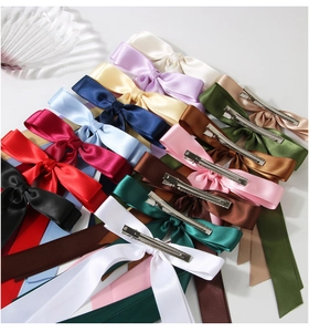 Détail de pinces à cheveux à nœuds en satin multicolore montrant la texture du tissu