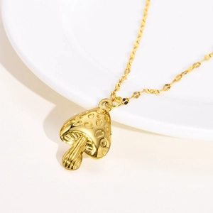 Macro shot of gold mushroom pendant with textured cap and vertical gill details