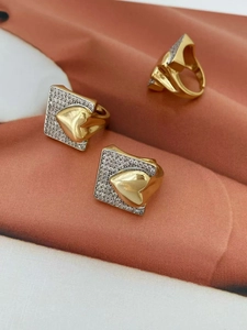 Close-up of three 18k gold plated heart rings with cubic zirconia pavé in square frames