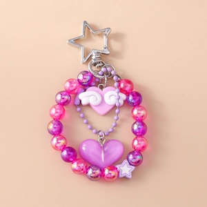 Close-up of pink and purple beaded keychain with winged heart and star pendants