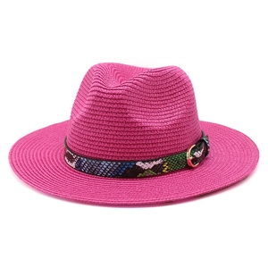 Detail of rose pink straw hat with colorful snake pattern band and gold metal buckle