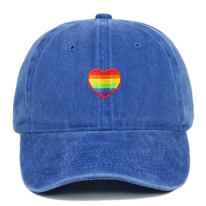 Close-up of rainbow heart embroidery on blue washed cotton baseball cap with fine stitching