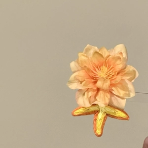 Exquisite handmade orange floral hair clip with elegant fabric petals and embroidered leaves