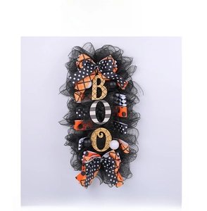 Detail of Halloween BOO wreath featuring black mesh, orange ribbons, and spider web letters