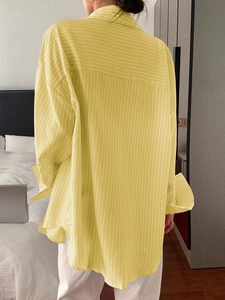 Detail view of the back of a casual yellow striped long sleeve shirt for women