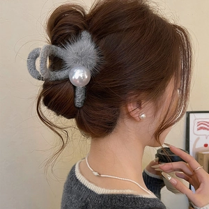Detail of plush grey claw clip with pearl accent styled in hair for a soft winter look
