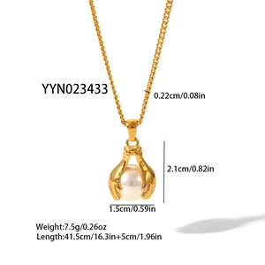 Gold stainless steel necklace featuring unique claw-set pearl pendant on white background