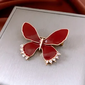 Vintage burgundy butterfly brooch with red enamel and crystals on gold metal trim