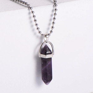 Macro detail of hexagonal amethyst pendant with silver mount and stainless steel ball chain
