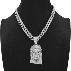 Detailed close-up of a silver iced-out Jesus portrait pendant on a Cuban link chain necklace