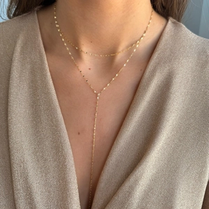 Detail view of double-layered gold Y-necklace in stainless steel on a model