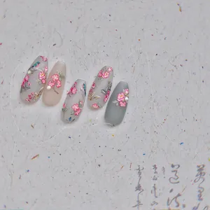 Macro detail of embossed nail stickers featuring floral patterns and pearl accents
