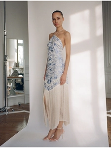 Detail of elegant halter neck floral dress featuring long tassel hem and open back design