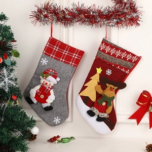 Christmas stockings with 3D snowman and reindeer patterns hanging on a festive wall