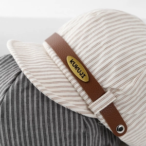 Striped baby navy hat with brown leather strap and gold brand plate detail