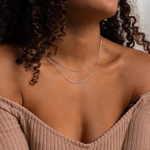 Close-up of double-layer silver snake chain necklace set worn on a model's neck