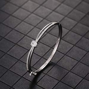 Detail shot of silver crossover bracelet with pavé cubic zirconia and round center stone