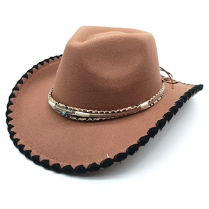 Detail of brown western cowboy hat with silver feather and turquoise stone ornament