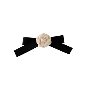 Elegant black velvet bow hair clip featuring a delicate cream camellia flower accessory