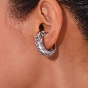 Detailed close-up of C-shaped ear cuff featuring a textured silver scale pattern on ear