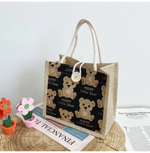 Detail of linen tote bag with cotton rope handle, button closure and bear print