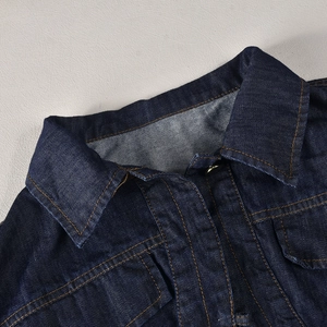 Detail of dark blue denim jacket collar and shoulder with contrast yellow stitching
