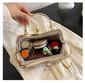 Detailed interior of vintage metal frame handbag showing large capacity for cosmetics