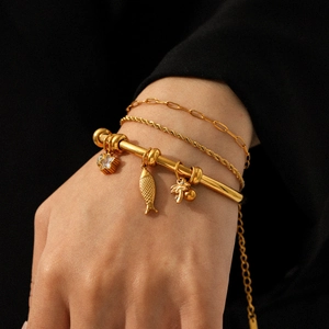 Ensemble de trois bracelets en acier inoxydable plaqué or 18 carats avec pendentifs poissons
