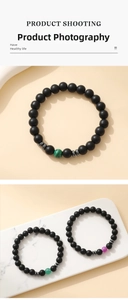 Detail of 8mm matte black stone bracelets with colorful beads on a marble display tray