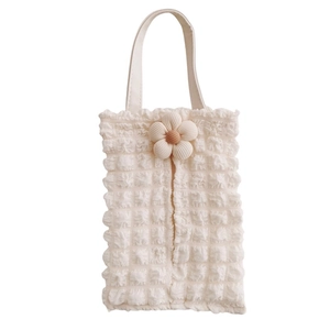 Close-up of cream textured bubble fabric car tissue holder with decorative flower