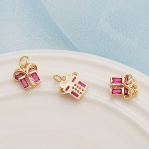 Detailed view of 14K gold plated gift box charms with pink gemstones and cubic zirconia