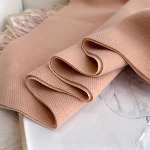 Close-up of pink imitation cashmere scarf with herringbone weave and elegant fringe detail